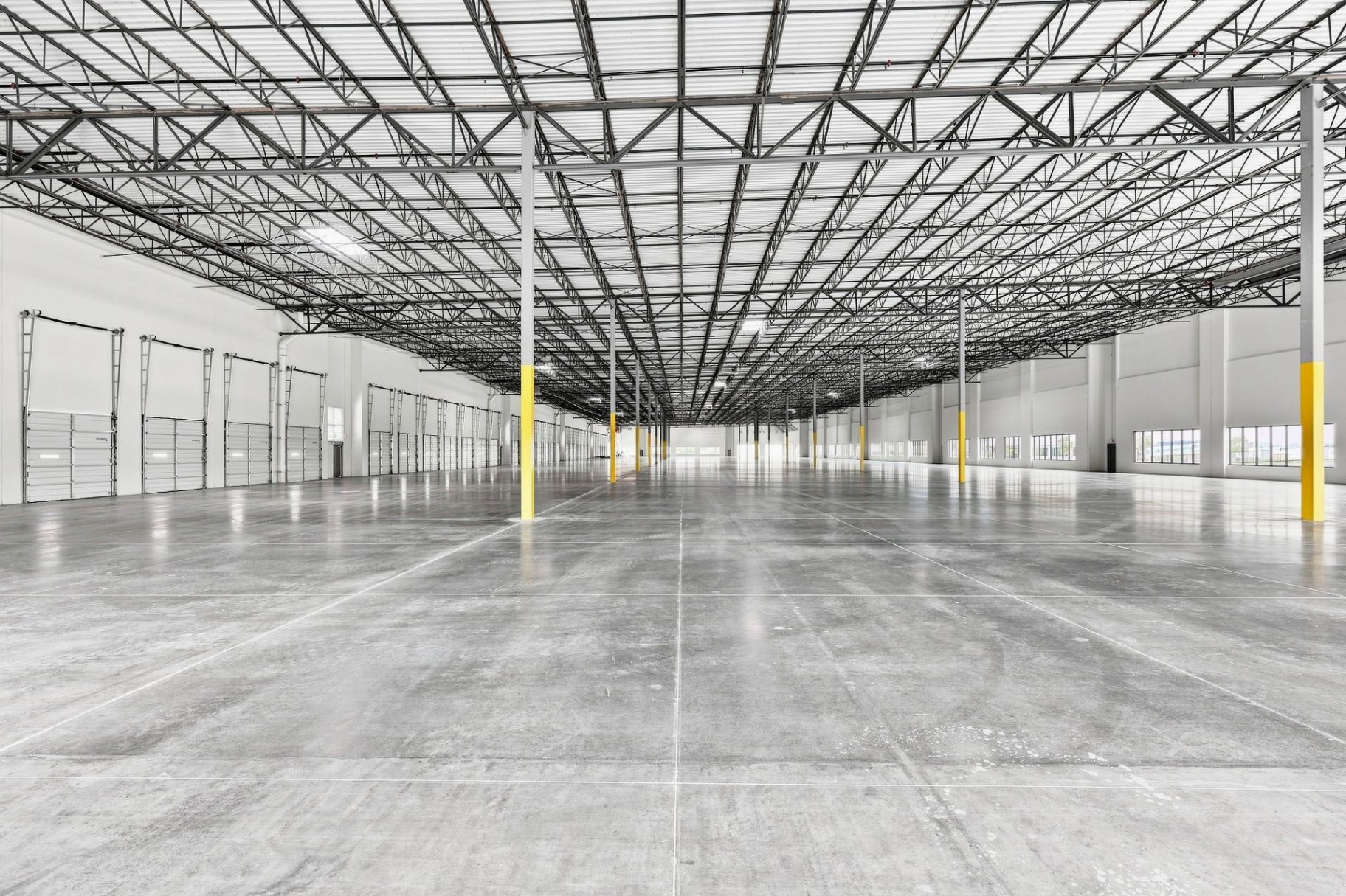 Interior view of a warehouse showing structural columns, ceiling structure, floor area, and depth