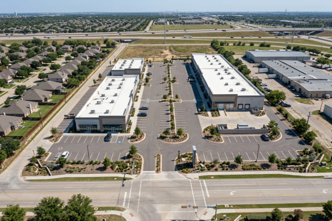 Aerial facility documentation showing two long commercial buildings, loading areas, parking, roads, and highway context
